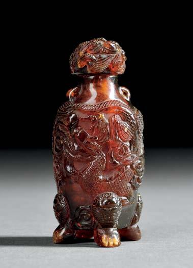 7 Red/brown Amber Snuff Bottle with Dragons, China, 18th/19th century, oviform, resting on four animal-head feet, two loops at the shoulder, well-hollowed, decorated with two swirling dragons chasing