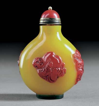 33 34 33 Peking Glass Snuff Bottle, China, Qing dynasty, flattened round form on a raised green oval foot, egg-yolk yellow with a red glass overlay carved with a bat and boys holding peaches, red