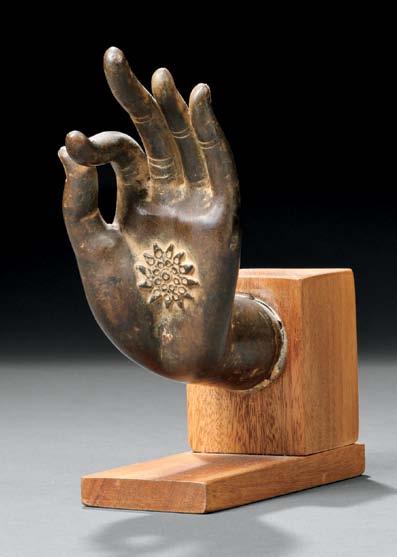 $500-700 66 Bronze Sukhothai-style Buddha Hand, Thailand, the left hand in vitarka mudra with a mandala on the palm, mounted on a modern wood stand, hand ht. 6, wd. 2 7/8 in.