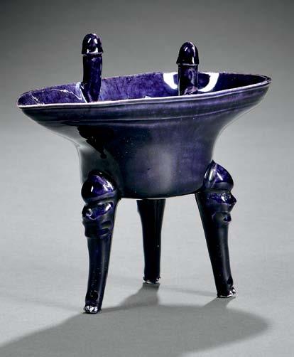 $400-600 121 Deep-purple-glazed Libation Cup, China, possibly Ming dynasty, tripod jue form, the oviform well with flat base and corn-shaped rim with two upright tubular finials, the exterior