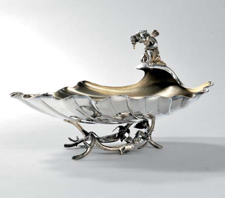 88 88 Gorham Sterling Silver Shell-form Dish, Providence, c. 1872, monogrammed, with a winged cupid perched on the uppermost edge dangling a cluster of grapes, on a faux-bois foot, lg. 10 in., approx.