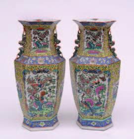 364 369 364 A pair of Canton famille rose vases of hexagonal section with buddhistic lion and puppy handles, painted overall with exotic birds and butterflies in garden settings within blue and