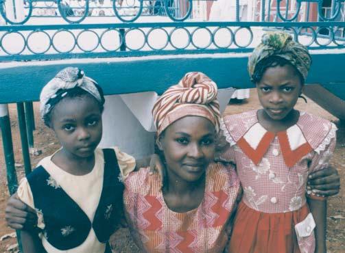 For a trip to the market, a simple headwrap knotted at the crown of the head suits this family. In West Africa headwraps are high fashion.