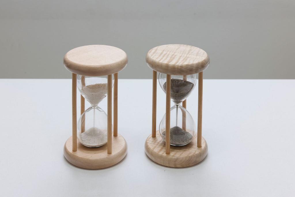 hourglasses, one containing sand from