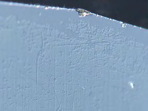 The Nomarski image (right) of the edge of one of the pavilion facets shows how the coating has worn away (photomicrograph by David Fisher).