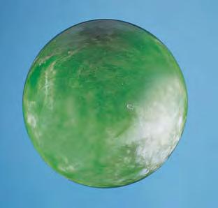 Figure 10. This mottled green-andgray sphere (63 mm in diameter) proved to be a talc-serpentine rock with a phosphorescent coating. from 1.56 in the green areas to as high as 1.60 in a gray area.