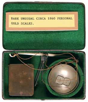 4113* Personal gold scales, circa 1860, original metal case, four brass weights inside little compartment, scale dishes hung on metal arms with balance needle. In good condition.