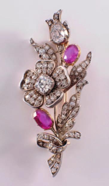 76 350 A ruby and diamond mounted floral spray brooch with single flower head, the central old brilliant-cut diamond approximately 1.