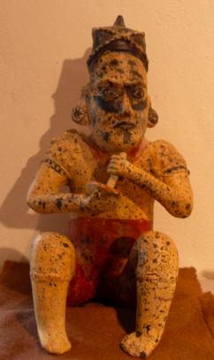 Seated Male Figure Holding Bowl and Drinking Tube This is an earthenware tomb figure from the Colima area of West Mexico.