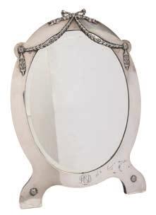 107 107 An Edward VII silver easel mirror, maker Elkington & Co, London, 1906 initialled, of oval outline, with tied garland decoration, with bevelled mirror plate, 39cm. high.