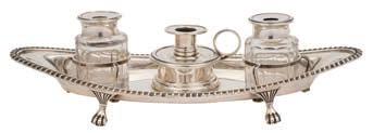 27 27 A George V silver inkstand, maker Ellis Jacob Greenberg, Birmingham, 1910 of oval outline with gadrooned border, the circular detachable taper stick flanked by two clear glass inkwells, raised