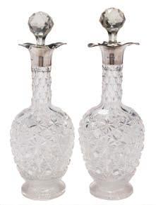 45 45 A pair of George V clear glass and silver mounted decanters and stoppers, maker Goldsmiths & Silversmiths Co Ltd, London, 1912 of baluster form with stellar and hobnail cut decoration, on a
