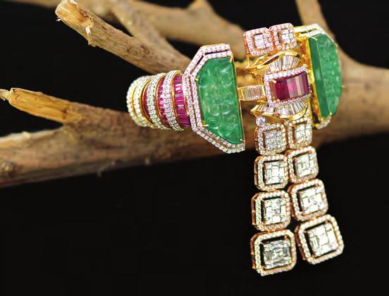 COVER STORY A gold bracelet studded with rubies and diamonds. The central emerald motif features a tassel of diamonds.