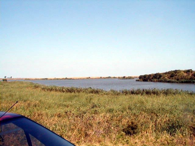 On the ground, a view from the shore of the lake. On the right side of the picture: the island where the Lake Town was situated.
