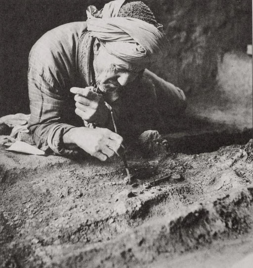 Afghan excavator carefully uncovers the dagger from Tomb 4, Tillya Tepe, 1978. Photo copyright Viktor Sarianidi. Reprinted with permission.