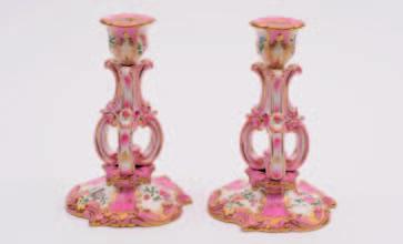A pair of Coalport match pots or spill vases of cylindrical form and set on three feet enamelled with floral panels, reserved on a pink ground, 12.5 cm high, circa.