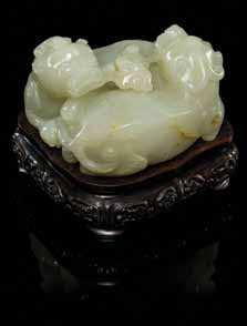 634 635 639 638 634 A Pale Celadon Jade Figural Group carved to show intertwined beasts, raised on a itted hardwood stand. Height 1 3/4 inches.