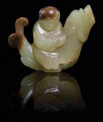20 A Jade Figural Group of a yellow stone and russet skin, depicting a child riding a chiwen.