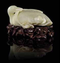 $800-1,200 30 Two Jade Toggles one of a pale celadon stone having russet skin, depicting a recumbent beast, the other of an even white stone, depicting a recumbent bear with a coiled tail.