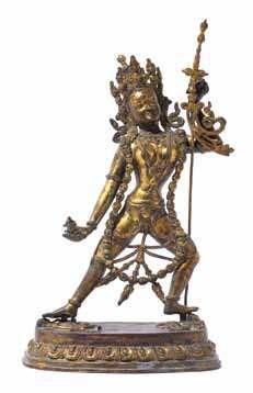 959 A Gilt Bronze Figure Of Vajrayogini the deity depicted standing on a lotus base in alidhasana wearing peaked crown and high chignon, the right hand bearing a tarkita, the left hand holding a