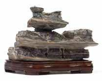 $1,200-1,500 168 A Scholar s Rock the dark grey stone of horizontal form with shaped peaks and irregular outlines, raised on a itted hardwood stand.