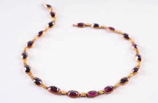 163 44 164 165 163. An antique gold and garnet necklace composed of seventeen oval and two pearshaped rose-cut garnets together with one upturned oval garnet each in a flat-backed setting. 800-1000.