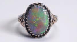 An early 20th century arts and crafts singlestone ring, the oval black opal 14mm x 10mm in claw setting between gold