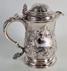 1000-1500 367 A GEORGE III EMBOSSED SCOTTISH SILVER TANKARD of baluster form with bulbous body, decorated in relief with floral chasing and