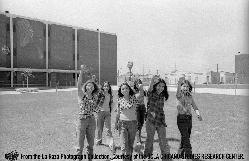 Children with raised fists during a Barrio Conference at Roosevelt High School Maria
