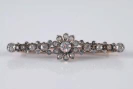 A diamond mounted floral cluster bar brooch with round old brilliant and rose cut stones, the central floral