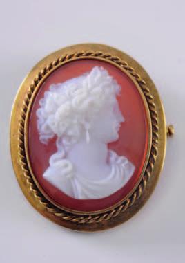 A late 19th century layered agate oval portrait brooch, the oval agate 34mm long, depicting a young woman, her hair adorned with vine leaves and grapes and wearing a drop earring within a rope twist