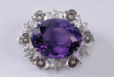 331 332 333 331. An amethyst mounted oval brooch with central, oval amethyst approximately 30mm x 23mm within floral surround, the reverse stamped 18ct. 550-700. 332. A gold and diamond mounted circular leaf spray brooch with three leaf clusters highlighted with old brilliantcut diamonds, 53mm long.