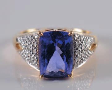 400 400. An 18ct gold, cushion-shaped tanzanite and diamond ring with central tanzanite stated to be AAA quality and weighing 3.