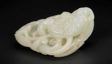 26 A QING DYNASTY WHITE AND RUSSET JADE BAT AND LOTUS GROUP White jade with sparse russet inclusions, smooth surface polish China, Qing Dynasty This fine white jade pebble combines the two auspicious