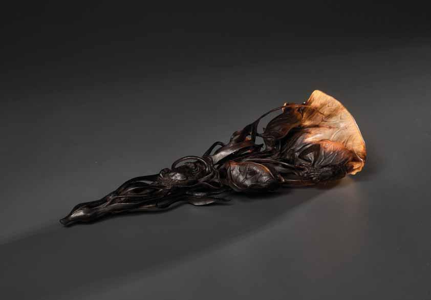 56 AN 18 TH CENTURY RETICULATED FULL TIP RHINOCEROS LOTUS CUP Rhinoceros horn in a deep brown to light honey hued color play with translucent quality China, 18 th century This masterly carved