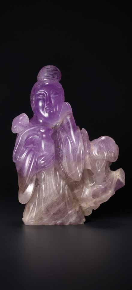 The artist has cleverly used the natural color play of the stone to highlight the upper part of the figure which stands out due to its purple hue whilst the rock and the lower part of the gown are of
