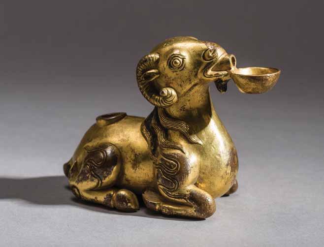 four-character Yongzheng mark on the bottom and possibly of the period (1723 1735) This well-cast fire gilt bronze water dropper depicts a reclining ram grasping a small bowl in its mouth.