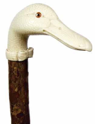 1900-Carved ivory duck with two color glass eyes which is fully carved, ivory bow tie collar, natural bark covered shaft and a horn H. 3 ½ x 2 ½, O.L. 34 ½ $1,000-$1,500 51.