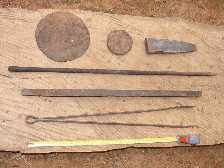 Hoe, Hoe Preform (lukopile), Iron Hammer Poker ( nlo) and Handler (kebao) The upper row shows a roughly finished metal hoe disk, an iron preform (lukopile) from which hoes and other tools can be
