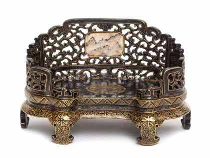 26 26 a Gilt decorated Black Glazed Porcelain Stand the pierce carved back set with a small panel painted to imitate black-veined pink marble, raised on six ruyi legs, the underside depicting two
