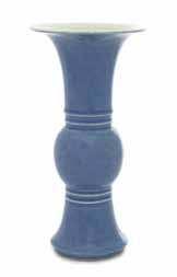 33 a clair-de-lune Glazed Porcelain Vase the ovoid body rising to a tall neck surmounted by a slightly laring mouth, carved with shou roundels and foliate scrolls below a band of lapped leaves, the