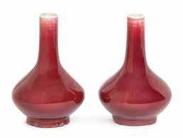 39* a Small Pair of Sang-de-Boeuf Glazed Porcelain Vases each of squat baluster form raised on a short foot rising to elongated neck, the allover deep red glaze fading to white at the mouth.