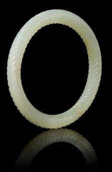 123 a White Jade archer s ring of a translucent stone with lared rims, the body incised with a gilt highlighted Qianlong imperial poem. Height 1 1/4 inches.