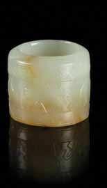 $800-1,200 128 two carved Jade articles the irst an ovular box cover set with a reticulated carved plaque depicting a chilong with russet skins, underside marked 925, the second a brooch carved to