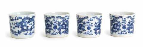 $200-400 160 a Set of Four Small Blue and White Porcelain cups GUanGXU PErioD (1875-1908) each of cylindrical form, painted to depict a dragon chasing the laming pearl of wisdom amongst clouds, the