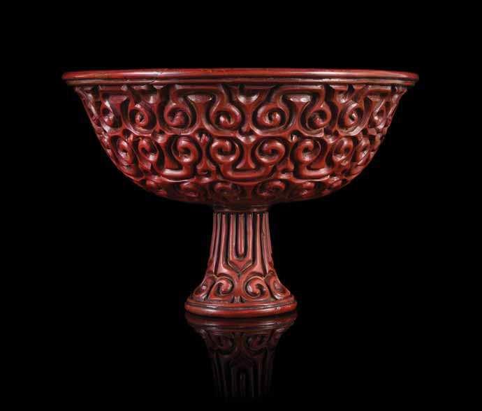 260 260 a Tixi cinnabar Lacquer Stembowl MinG DYnastY having deep rounded walls, supported on a tall spreading feet rising to a slightly lared mouth rim, densely carved to the exterior with overall