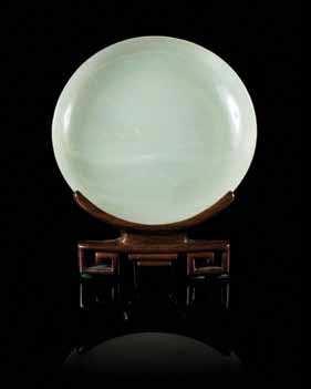 293 295 296 297 293* a Pale celadon Jade circular dish of a transparent stone, raised on a hardwood stand. Diameter 5 1/8 inches. Property from the Estate of Daniel a.