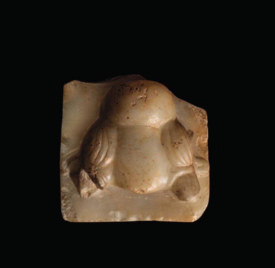 79. South Arabian alabaster stele fragment with a bull head carved in high relief, incised detailing to the eyes, brows and muzzle, the small, low relief ears protrude from behind the horns.