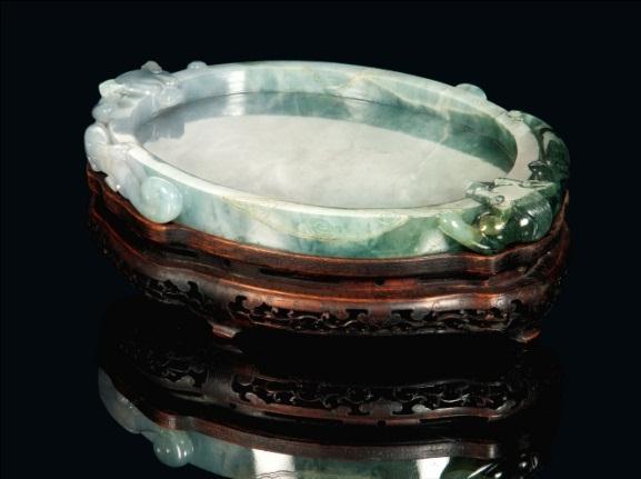 celadon jade circular table screen, Qianlong period (1736-1795) (estimate: 80,000-120,000); a pale celadon jade naturalistic carving of a bitter melon on a carved ivory stand (estimate:
