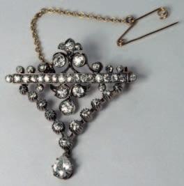 234. A pair of diamond mounted clip brooches, of stylised ribbon scroll design, channel and claw-set with